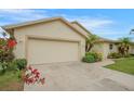 This image showcases the home's spacious two-car garage, complemented by a neatly landscaped front yard at 2710 93Rd E Ct, Palmetto, FL 34221