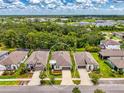 Aerial shot of a home with lush green landscaping under a partly cloudy blue sky at 3602 Secret Stroll Dr, Sarasota, FL 34240