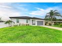 Charming one-story home with manicured lawn, gray garage door, and lush tropical landscaping at 4314 Des Plaines Dr, Sarasota, FL 34233