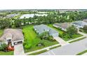 Aerial view of a well-maintained home and lush green landscaping, set in a scenic residential area near a lake at 4654 Claremont Park Dr, Bradenton, FL 34211