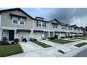 Street view of beige two-story townhomes with garages and blue doors at 5812 Ocean Isle Dr, Nokomis, FL 34275