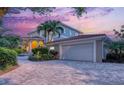 Beautiful home exterior with a paved driveway, well-maintained landscaping, and a spacious two-car garage at 585 Gunwale Ln, Longboat Key, FL 34228