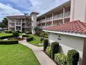 Condo building with manicured lawn and flower beds at 6505 Stone River Rd # 309, Bradenton, FL 34203