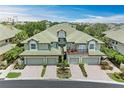 An inviting shot of the home's facade, featuring a two-car garage, lush landscaping, and a welcoming entryway at 6536 Moorings Point Cir # 101, Lakewood Ranch, FL 34202