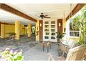 Covered ground floor featuring a seating area, ceiling fan, and a welcoming front door at 701 Marbury Lane, Longboat Key, FL 34228