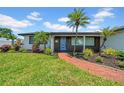 Beautiful one story home boasts a brick walkway and lush tropical landscaping at 8001 13Th S Ave, St Petersburg, FL 33707