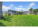 Green lawn with home featuring mature trees and lovely landscaping at 8001 13Th S Ave, St Petersburg, FL 33707