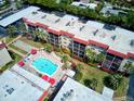 Inviting condominium complex featuring a sparkling blue pool, well maintained grounds and red umbrella accents at 915 Beach Rd # 321, Sarasota, FL 34242