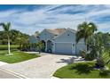 Charming home with meticulous landscaping, a paver driveway, and a three-car garage situated on a lush lot at 15808 42Nd E Gln, Parrish, FL 34219