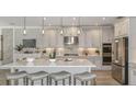 Modern kitchen featuring a large island with seating, stainless steel appliances, and stylish pendant lighting at 16415 Star Grass Cir, Bradenton, FL 34211