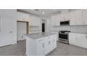Spacious kitchen with white cabinets, stainless steel appliances, and granite countertops on a large island at 18068 Cherished Loop, Bradenton, FL 34211