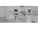 Stylish kitchen boasts white cabinetry, stainless steel appliances, and granite countertops at 18068 Cherished Loop, Bradenton, FL 34211