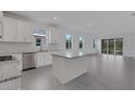 Bright, open kitchen featuring white cabinets, stainless steel appliances, and a granite island at 18068 Cherished Loop, Bradenton, FL 34211