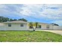 Beautiful single-story home with a lush green lawn and charming palm trees at 2004 40Th W St, Bradenton, FL 34205