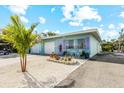 Stylish home with a light blue exterior, white garage door, and vibrant purple door and shutter accents at 441 62Nd St, Holmes Beach, FL 34217