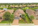 Aerial view of a single-story home with tile roof, surrounded by landscaped yard and serene community lakes at 5596 Cantucci St, Nokomis, FL 34275