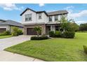 Attractive two-story house with stone accents, a brown garage door, and lush green landscaping at 731 116Th Ne Ct, Bradenton, FL 34212