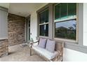 Inviting porch with a comfortable bench, neutral pillows, and stylish stone and tile accents at 731 116Th Ne Ct, Bradenton, FL 34212