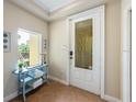 Lovely entryway with decorative door and sidelight window, table with blue towels, and tile flooring at 7324 Gulf Dr # 12, Holmes Beach, FL 34217