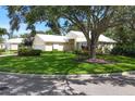 Stunning single-story home with a lush green lawn, mature trees, and a well-maintained landscape at 7904 Hampton Ct, University Park, FL 34201