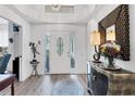 Bright foyer with an oval glass door, elegant decor, mirror, and striking light fixture at 7904 Hampton Ct, University Park, FL 34201