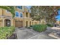 Well-maintained townhome exterior showcasing a private garage, stone accents, and lush landscaping at 8823 White Sage Loop # 1802, Lakewood Ranch, FL 34202