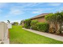 Lush green side yard with a concrete walkway and vibrant flowering bushes and colorful foliage at 2819 47Th E St, Palmetto, FL 34221