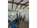 Bright living room showcasing vaulted ceilings with wooden beams, and an open design flowing into the kitchen at 5231 Brassy Loop, North Port, FL 34287