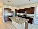 Spacious kitchen with granite countertops, stainless steel appliances, and a center island at 8697 Milestone Dr, Sarasota, FL 34238