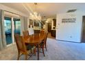 Dining room with chandelier, carpeted floors, and view of the kitchen at 13133 Lola Dr, Spring Hill, FL 34609