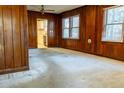 Living room featuring wood paneled walls, carpet, and a bright window at 126 W North St, Tampa, FL 33604