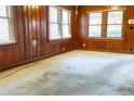 Living room featuring wood paneled walls, carpet, and a bright window at 126 W North St, Tampa, FL 33604