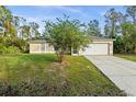 Tan one story house with attached garage and landscaped lawn at 1340 Papillon St, North Port, FL 34287