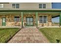 Inviting front porch with stone detailing and a brick walkway at 48665 Bermont Rd, Punta Gorda, FL 33982