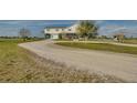 Gravel driveway leading to a large two-story home at 48665 Bermont Rd, Punta Gorda, FL 33982