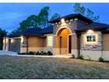 Home exterior with a two-car garage, stone accents, and arched entryway at 4209 Titan St, North Port, FL 34286
