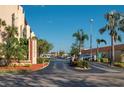 Entrance to a multi-story building with lush green palm trees on a sunny day at 3006 Caring Way # 325, Port Charlotte, FL 33952