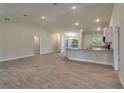 Open-concept living space with wood-look tile floors, neutral paint, and recessed lighting at 3482 Dunkirk St, Port Charlotte, FL 33980