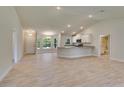 Bright open-concept living space with wood-look tile floors and natural light throughout at 3482 Dunkirk St, Port Charlotte, FL 33980