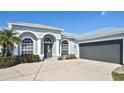 Single-story home with light gray exterior, metal roof, and two-car garage at 7417 S Moss Rose, Punta Gorda, FL 33955