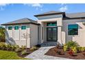 Front view of house showcasing entryway and landscaping at 9445 Galaxie Cir, Port Charlotte, FL 33981