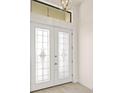 White double front doors with glass inserts and light-colored flooring at 9445 Galaxie Cir, Port Charlotte, FL 33981