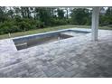 The home features an outdoor patio with decorative pavers surrounding a concrete pool at 8285 Agate St, Port Charlotte, FL 33981