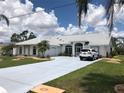 Single-Gathering home with driveway and landscaped lawn at 303 San Cristobal Ave, Punta Gorda, FL 33983