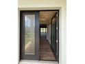 Welcoming entrance featuring a modern chandelier, wood-look floors, and a stylish barn door detail at 13654 Allamanda Cir, Port Charlotte, FL 33981