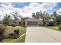 House exterior showing a peach-colored home with a two-car garage and landscaping at 11907 De Leon Dr, North Port, FL 34287