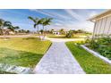 Brick pathway meandering through a lush green lawn at 2033 Treasure Ln, Punta Gorda, FL 33982