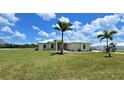Single-Gathering home with a manicured lawn and palm trees at 28944 Gin Ln, Punta Gorda, FL 33982