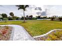 Landscaped front yard with a paved walkway and tropical plants at 28944 Gin Ln, Punta Gorda, FL 33982