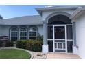 Front entrance with a red door, white columns, and landscaping at 431 San Felix St, Punta Gorda, FL 33983